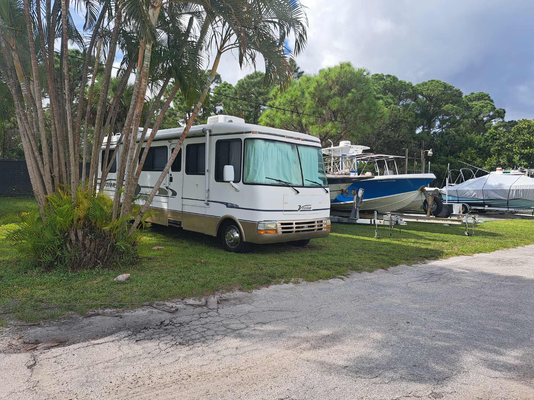 RV lot with boat storage and palm trees at Twin Rivers